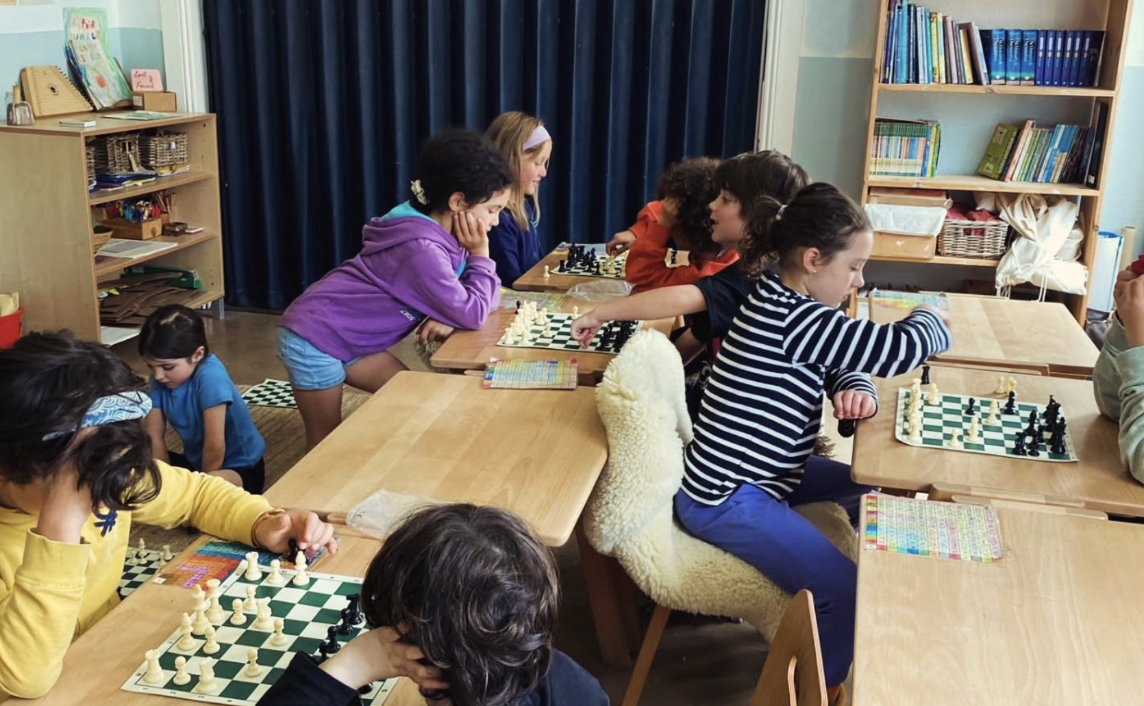 A CheckMates instructor teaching chess at a school
